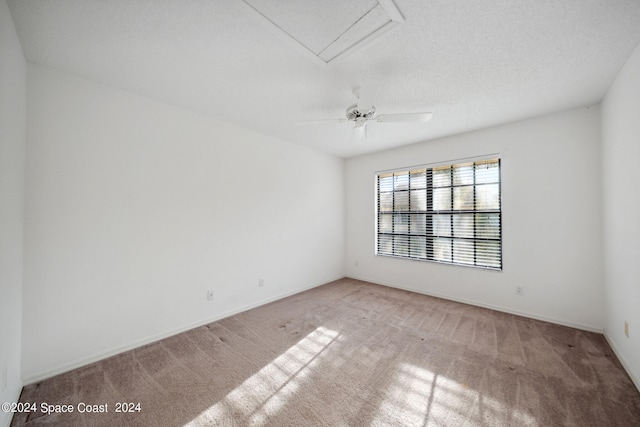 empty room with light carpet, ceiling fan, and a textured ceiling