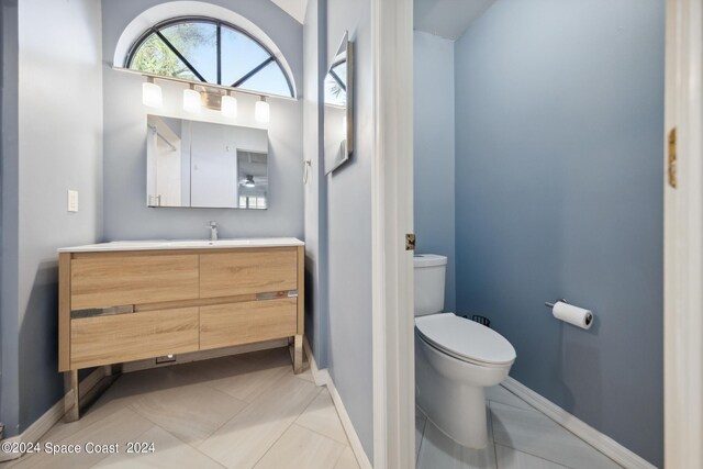 bathroom featuring tile patterned flooring, vanity, and toilet