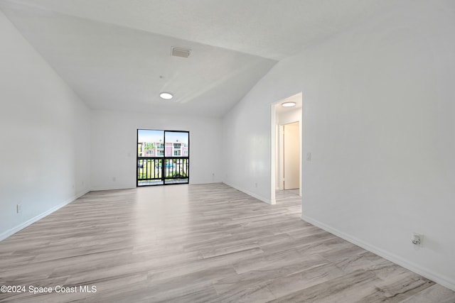 empty room with light hardwood / wood-style flooring and lofted ceiling