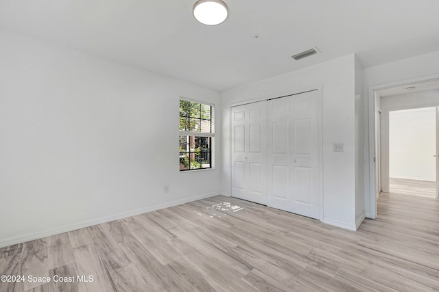 unfurnished bedroom featuring a closet and light hardwood / wood-style floors