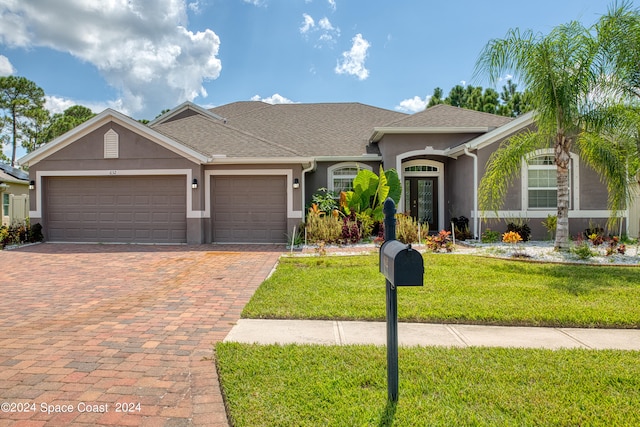 ranch-style home with a front lawn and a garage