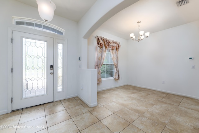 tiled foyer featuring a chandelier