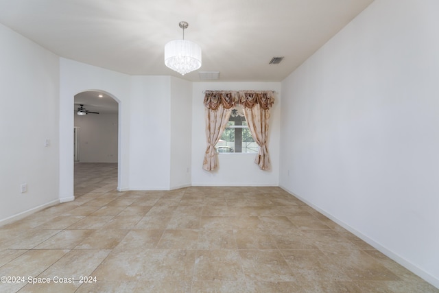 empty room with ceiling fan with notable chandelier