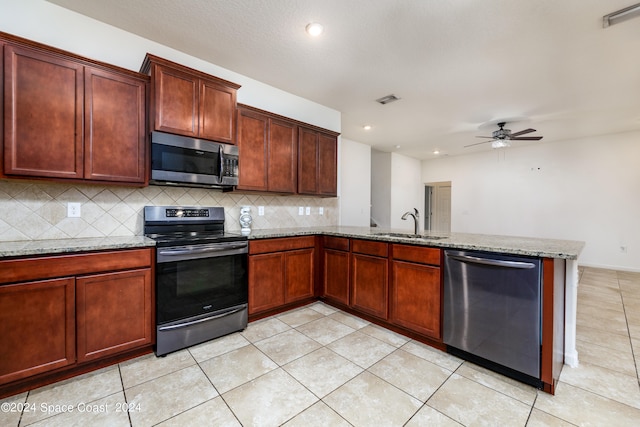 kitchen featuring light stone counters, sink, backsplash, appliances with stainless steel finishes, and ceiling fan