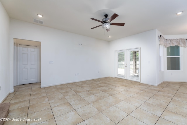 empty room featuring french doors, ceiling fan, and light tile patterned flooring