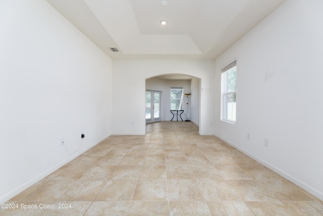 unfurnished room featuring a raised ceiling