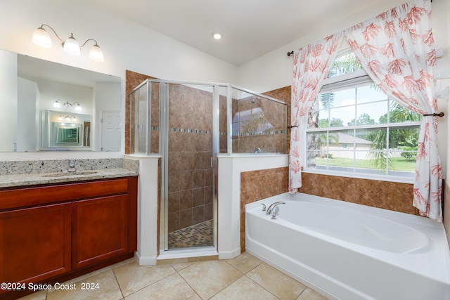 bathroom featuring vanity, plus walk in shower, and tile patterned flooring