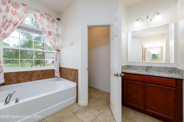 bathroom featuring vanity, tile patterned flooring, and a tub