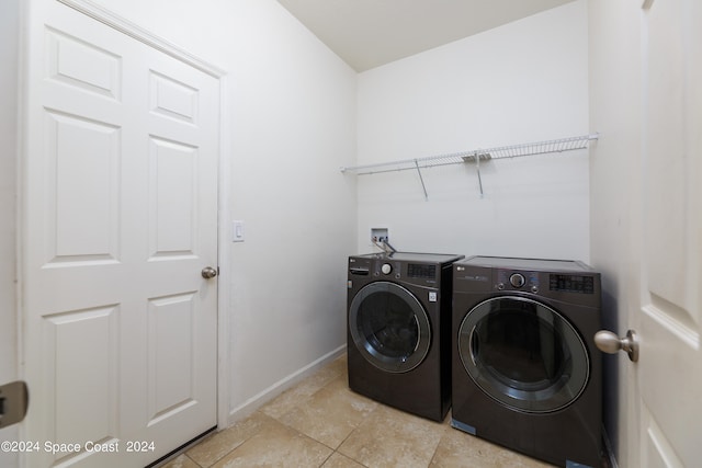 laundry room featuring washer and clothes dryer and light tile patterned floors