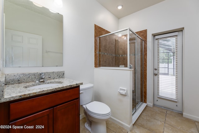 bathroom featuring walk in shower, vanity, tile patterned flooring, and toilet