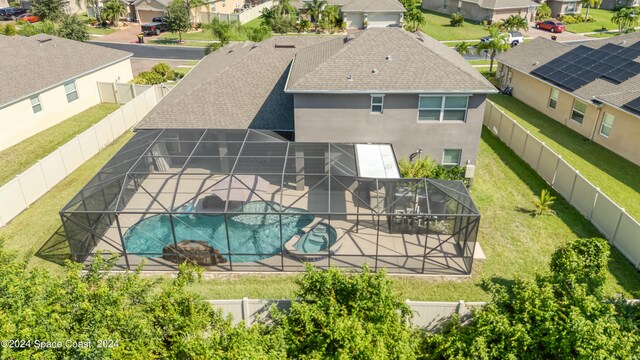 view of swimming pool with glass enclosure, a patio area, and a yard