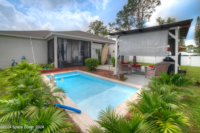 view of pool with an outdoor living space, a sunroom, and a patio area