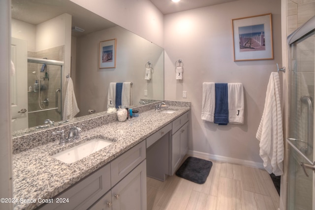 bathroom with vanity and a shower with door