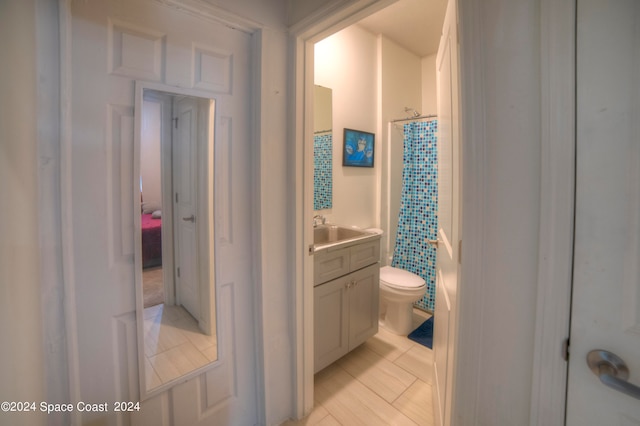 bathroom with a shower with shower curtain, vanity, toilet, and tile patterned floors