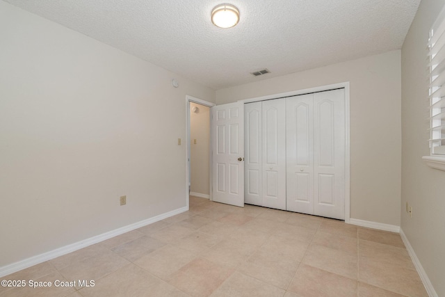 unfurnished bedroom featuring a closet and a textured ceiling