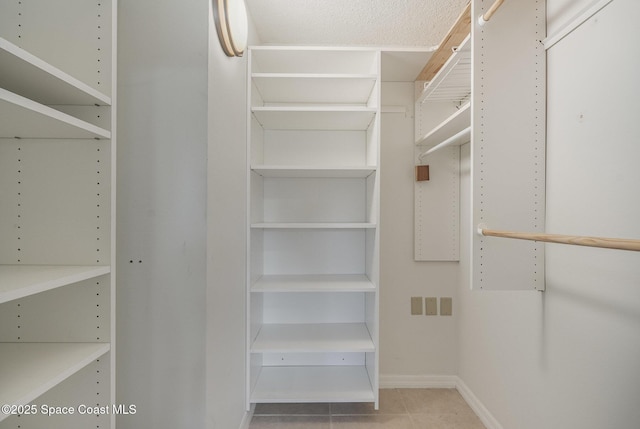 spacious closet featuring light tile patterned flooring