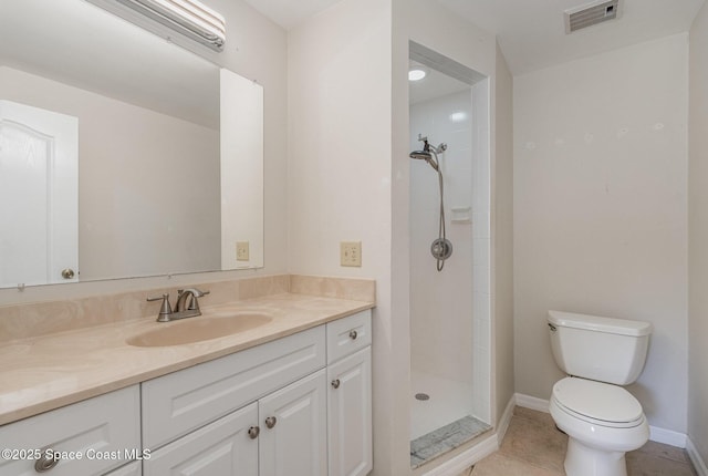 bathroom with tiled shower, vanity, toilet, and tile patterned floors