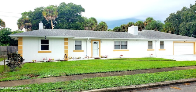 ranch-style home featuring a front lawn and a garage