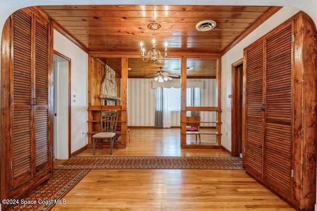 hall with light hardwood / wood-style flooring, wooden ceiling, and crown molding