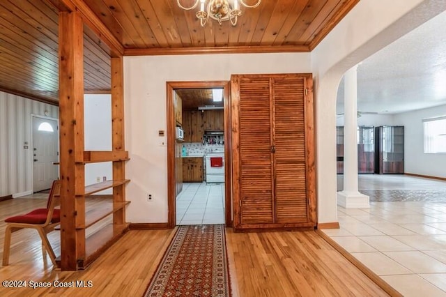 corridor featuring wood ceiling, ornamental molding, and light tile patterned floors