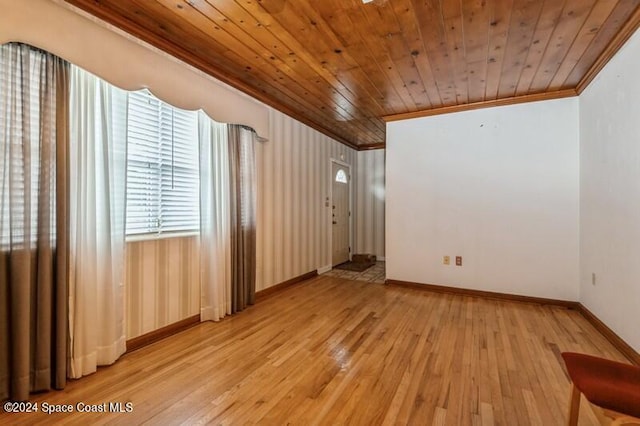 empty room featuring wood ceiling, crown molding, and light hardwood / wood-style flooring