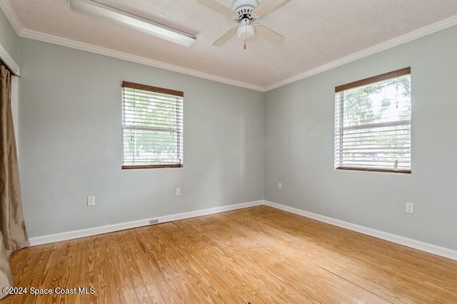 spare room with hardwood / wood-style floors, crown molding, and ceiling fan