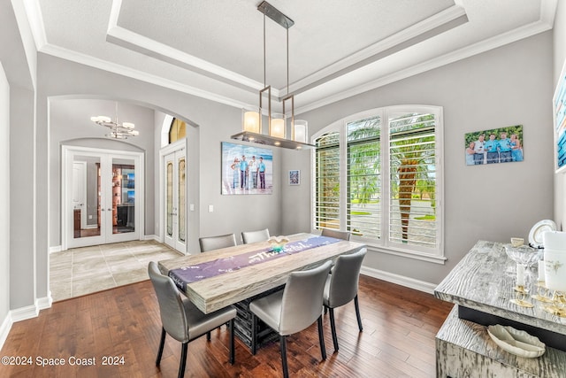 dining room featuring hardwood / wood-style floors, a textured ceiling, crown molding, and a tray ceiling