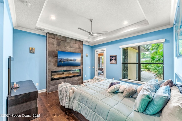 bedroom with a raised ceiling, ceiling fan, a textured ceiling, and dark hardwood / wood-style floors