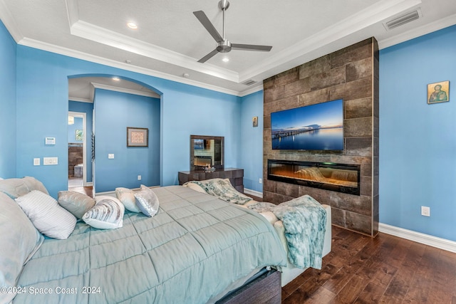 bedroom with ceiling fan, dark hardwood / wood-style floors, ornamental molding, and a tray ceiling