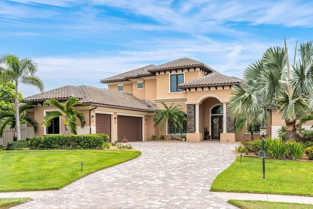 mediterranean / spanish-style house featuring a garage and a front lawn