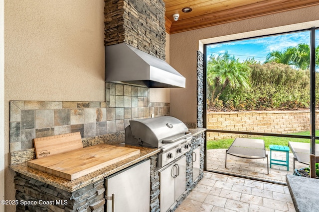 view of patio / terrace with exterior kitchen and a grill