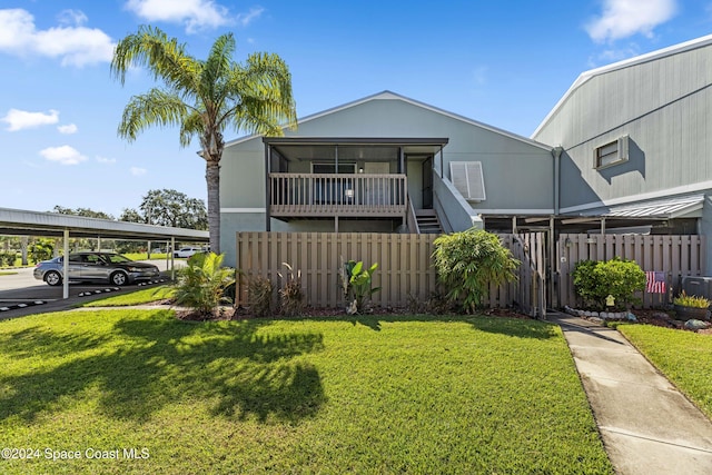 view of front of property featuring a front lawn and a carport