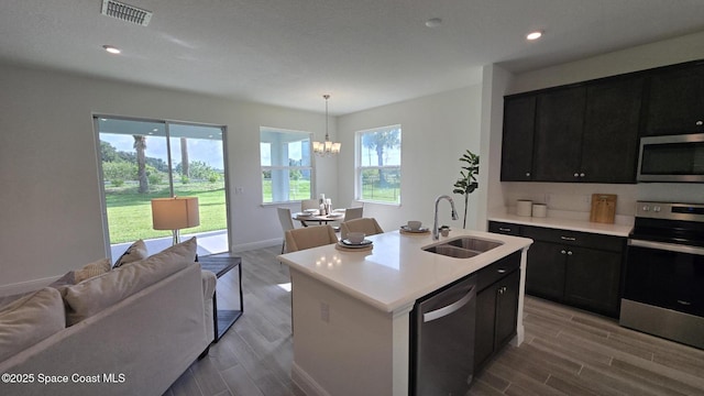 4346 Kelsey Ln, Sebastian, FL 32976 - kitchen with appliances with stainless steel finishes, open floor plan, dark cabinets, light countertops, and wood finished floors