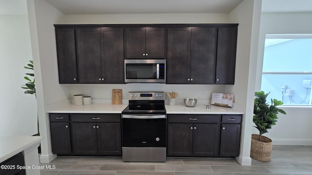 4346 Kelsey Ln, Sebastian, FL 32976 - kitchen featuring stainless steel appliances, wood tiled floors, light countertops, and dark brown cabinets