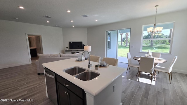 4346 Kelsey Ln, Sebastian, FL 32976 - kitchen with stainless steel dishwasher, dark wood-type flooring, a center island with sink, light countertops, and recessed lighting