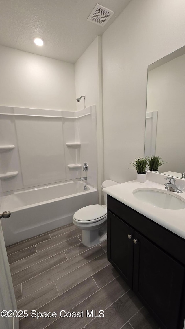 4346 Kelsey Ln, Sebastian, FL 32976 - full bathroom featuring vanity, washtub / shower combination, wood tiled floors, a textured ceiling, and recessed lighting