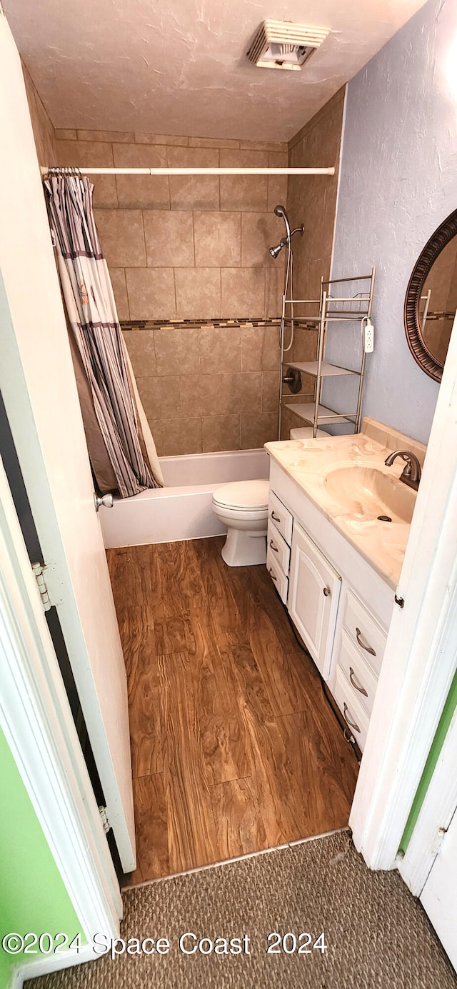 full bathroom with hardwood / wood-style flooring, vanity, toilet, and shower / bath combination with curtain