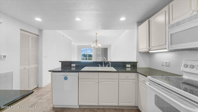 kitchen with white cabinets, sink, white appliances, a textured ceiling, and a notable chandelier