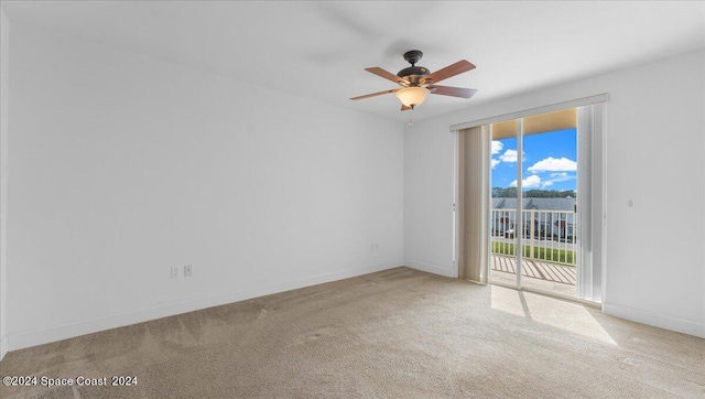 carpeted spare room featuring ceiling fan