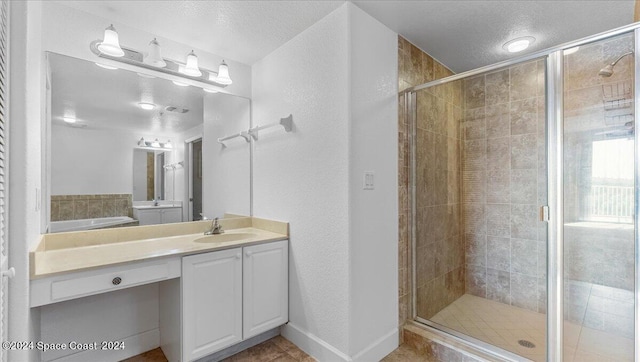 bathroom with vanity, a textured ceiling, an enclosed shower, and tile patterned floors