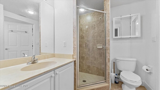 bathroom with vanity, tile patterned flooring, a shower with shower door, and toilet