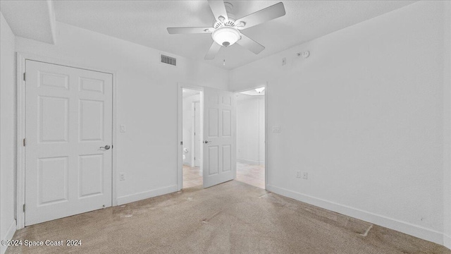 unfurnished bedroom featuring light carpet and ceiling fan