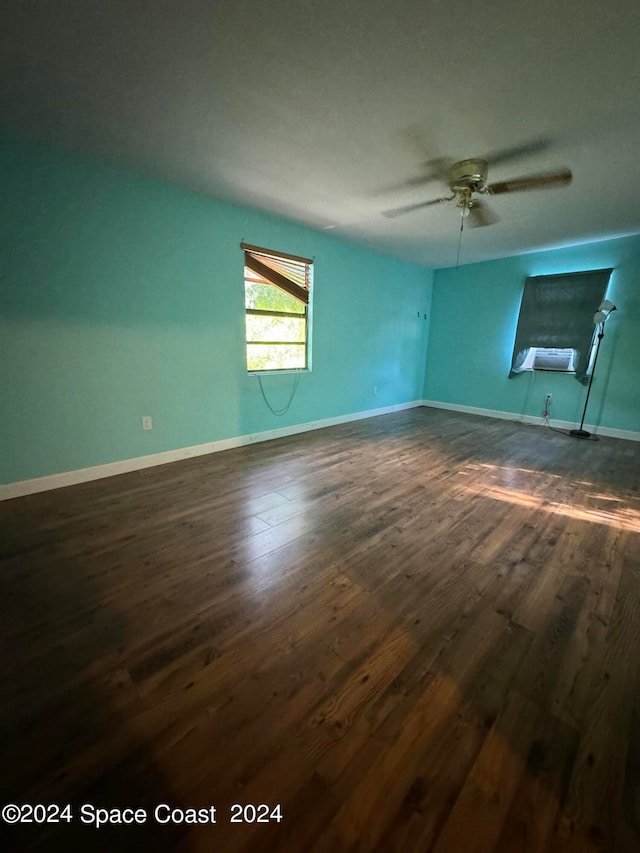 unfurnished room with ceiling fan and dark wood-type flooring