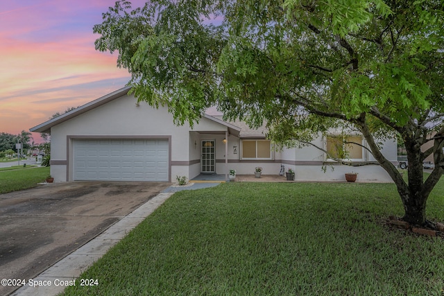 single story home featuring a yard and a garage