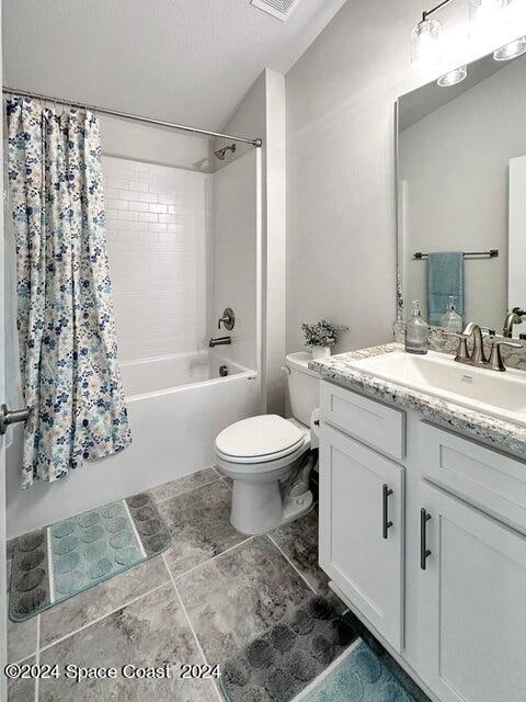 full bathroom featuring shower / bath combination with curtain, vanity, and toilet