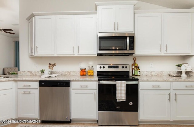 1182 Tupelo Cir, Cocoa, FL 32926 - kitchen with appliances with stainless steel finishes, white cabinetry, light stone counters, and ceiling fan