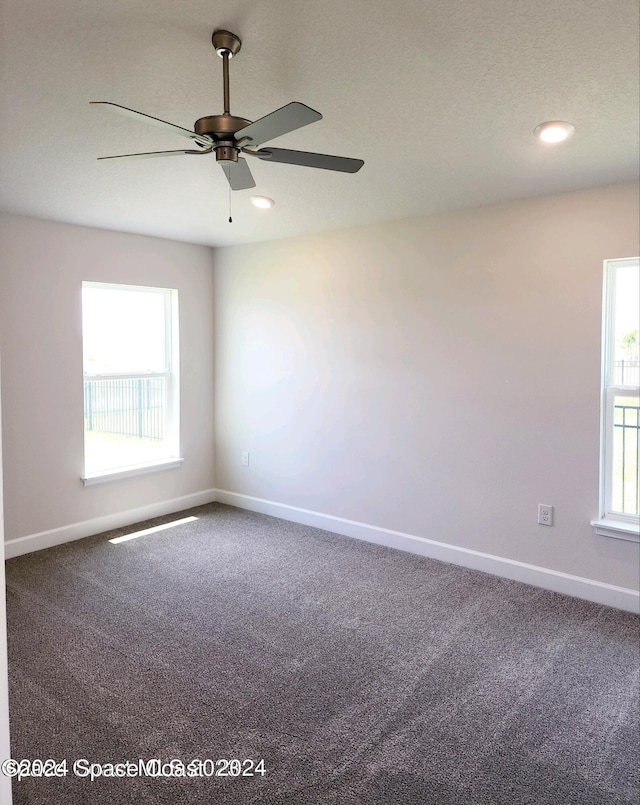 carpeted empty room with ceiling fan and a textured ceiling