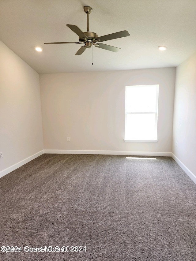 unfurnished room with ceiling fan and carpet