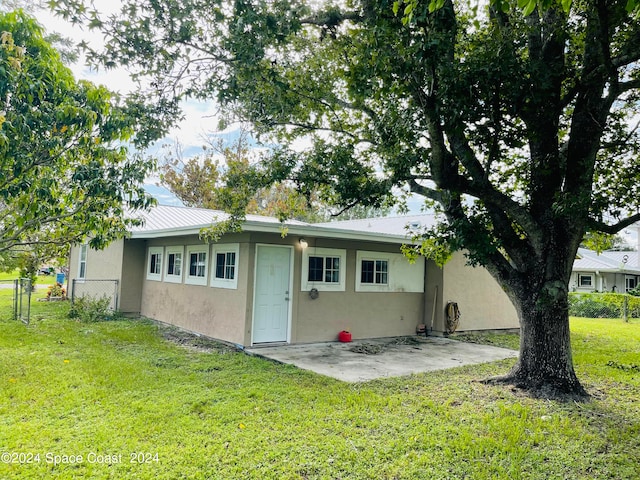 rear view of property with a lawn and a patio area