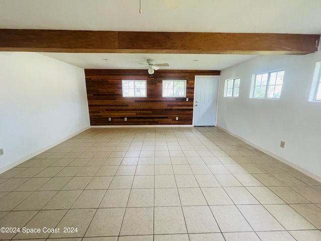 tiled spare room with beam ceiling and ceiling fan